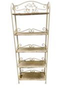Vintage style rustic and slightly rusty narrow metal shelving unit, with scrolling iron work
