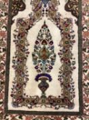 Small cream ground rug, with all over green and multicolour boarder and central vase and flower