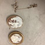 Two unmarked yellow metal mounted shell cameo brooches, and a white metal and paste monkey brooch