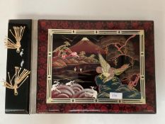 An Oriental style musical photo album with lacquer and faux mother of pearl decoration