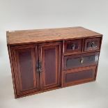 An Early C20th Chinese table top cabinet, two cupboard doors with two long and two short drawers, 56
