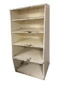 A large tiered bookcase also used as shop display stand, and cutlery serving stand, and kitchen