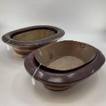 A C19th style Chinese Brass bound elm swallow, baths or basins, one with left out copper insert,