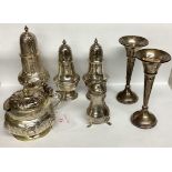 A collection of sterling silver and white metal items to include pepperettes and a pair of trumpet