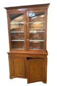 A two-section mahogany bookcase, the upper section with two glazed panelled doors, and a pair of