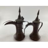 Two middle eastern copper coffee pots with traditional chased design, largest 34cm