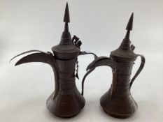 Two middle eastern copper coffee pots with traditional chased design, largest 34cm