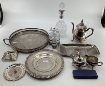A collection of silver plated wares to include a white metal collared decanter, tray and other items