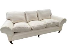 A good GEORGE SMITH three seater cream upholstered sofa, raised on wooden feet to brass castors, 230