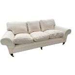 A good GEORGE SMITH three seater cream upholstered sofa, raised on wooden feet to brass castors, 230