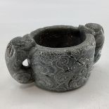 A Scandinavian soap stone Folk Art mug with twin stylised serpent handles, 7cm x 16cmW