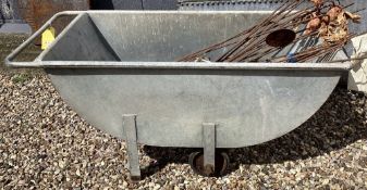 A galvanised metal feed or mash barrow