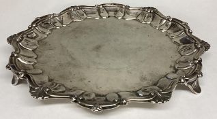 A Sterling silver circular card tray with scalloped edge on three feet, 324g, 22cm diam, by Lee &