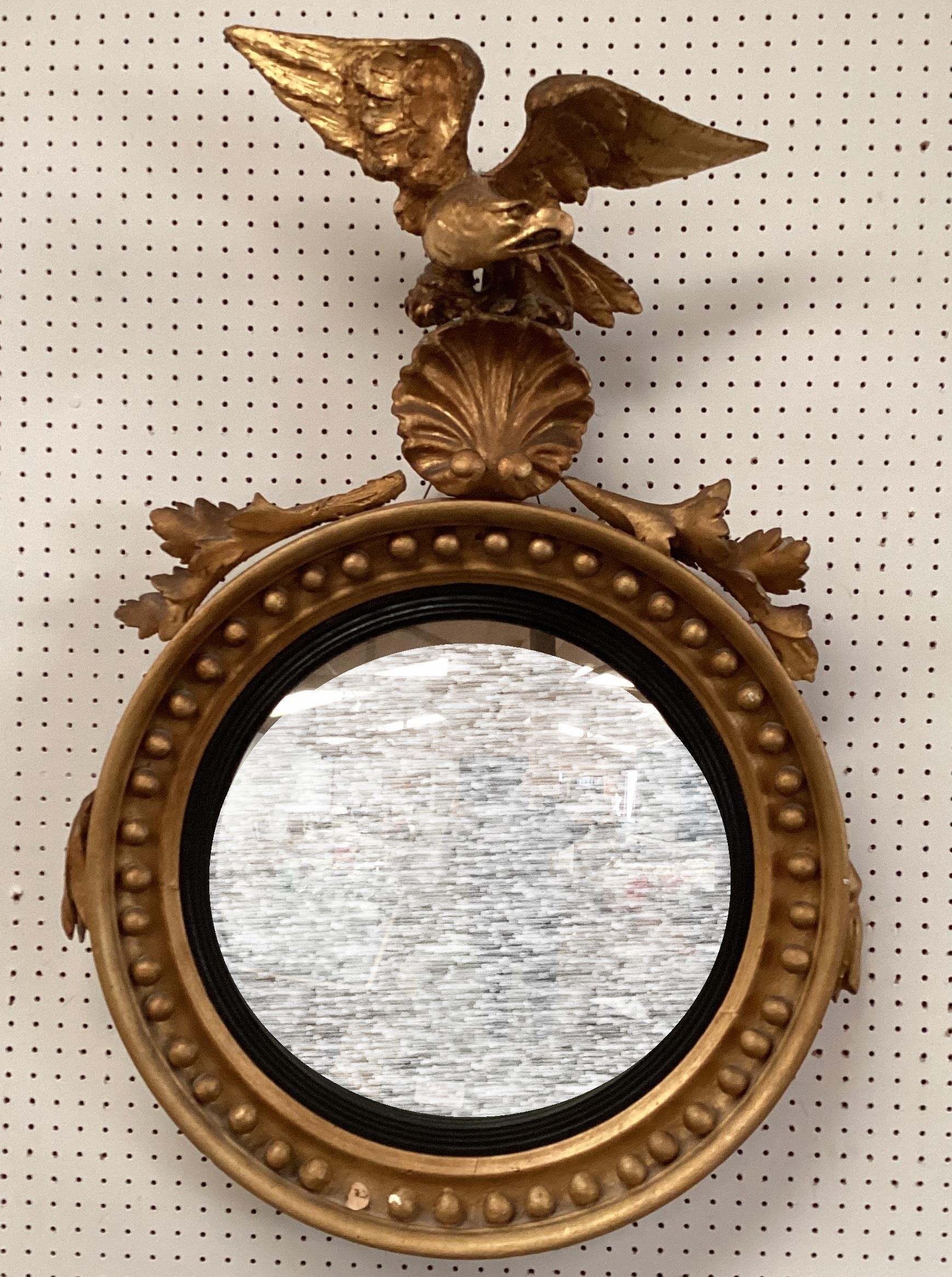 An antique Irish Style, gilt gesso convex circular wall mirror, with ball decoration beneath an