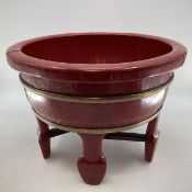 A Chinese brass bound lacquer wash bowl of circular form, with wide flat bottom, raised on four feet