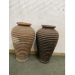 Two similar terracotta tall ribbed hoop pattern urns/pots, 65cm H