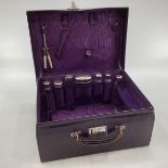 Vintage purple leather travel vanity case with fitted interior containing numerous white metal