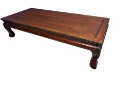 A large Oriental low table on four carved stylised feet, 200 x 91 x 50cm