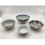 Four oriental style bowls of different designs, one with four character mark within double blue