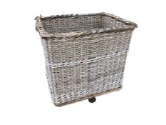 A very large vintage wicker laundry basket/ log/wood basket. Some wear to wheels/base. Very