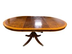 A walnut veneered style circular dining table, with leaves to extend