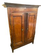 A Continental fruit wood Armoire, on raised legs with two doors and drawers and shelves to interior,