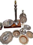 A collection of silver plate to include a column lamp, go to bed , wine coasters etc.