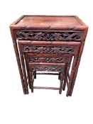 A nest of four oriental hardwood tables, with pierced gallery and faux bamboo legs, 71cm h
