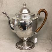 A large Sterling silver coffee pot in The Adams style with fruit wood handle on oval stepped base by