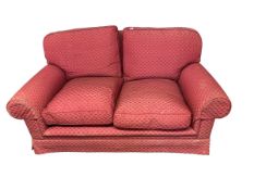 A red upholstered two seater sofa, some general wear