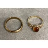 A 9ct gold orange garnet (spessartite) set dress ring together with a 9ct gold band. 5.73g. Size O/N