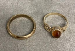 A 9ct gold orange garnet (spessartite) set dress ring together with a 9ct gold band. 5.73g. Size O/N