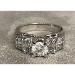 A 14ct white gold and diamond ring. Central brilliant cut diamond approx. 5mm with 14 diamond