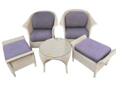 A five piece suite of furniture, to include two wicker arm chairs, circular glass top coffee