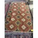RUG: modern Kilim, all over terracotta ground, with stylized lozzinge patterns in blues and