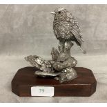 A sterling silver weighted model of a bird on a branch with a mahogany plinth base. 14cm(h)