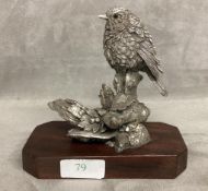 A sterling silver weighted model of a bird on a branch with a mahogany plinth base. 14cm(h)