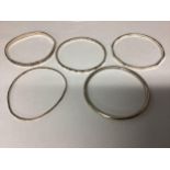 A collection of five bangles, four sterling silver and one unmarked white metal. 54g