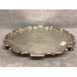 A sterling silver circular tray raised on three ball and claw feet by Thomas Eady and Co Ltd, London