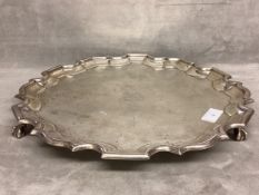 A sterling silver circular tray raised on three ball and claw feet by Thomas Eady and Co Ltd, London