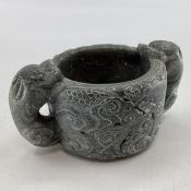 A Scandinavian soap stone Folk Art mug with twin stylised serpent handles, 7cm x 16cmW