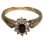 A 9ct gold ruby and diamond ring. Central oval free cut ruby with a surround of single cut diamonds.