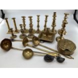 A collection of brass items to include 5 pairs of candlesticks, a 19th century go to bed, large