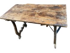 A C19th Continental rustic plank top table, with lyre shaped ends ends and iron work to stretchers ,