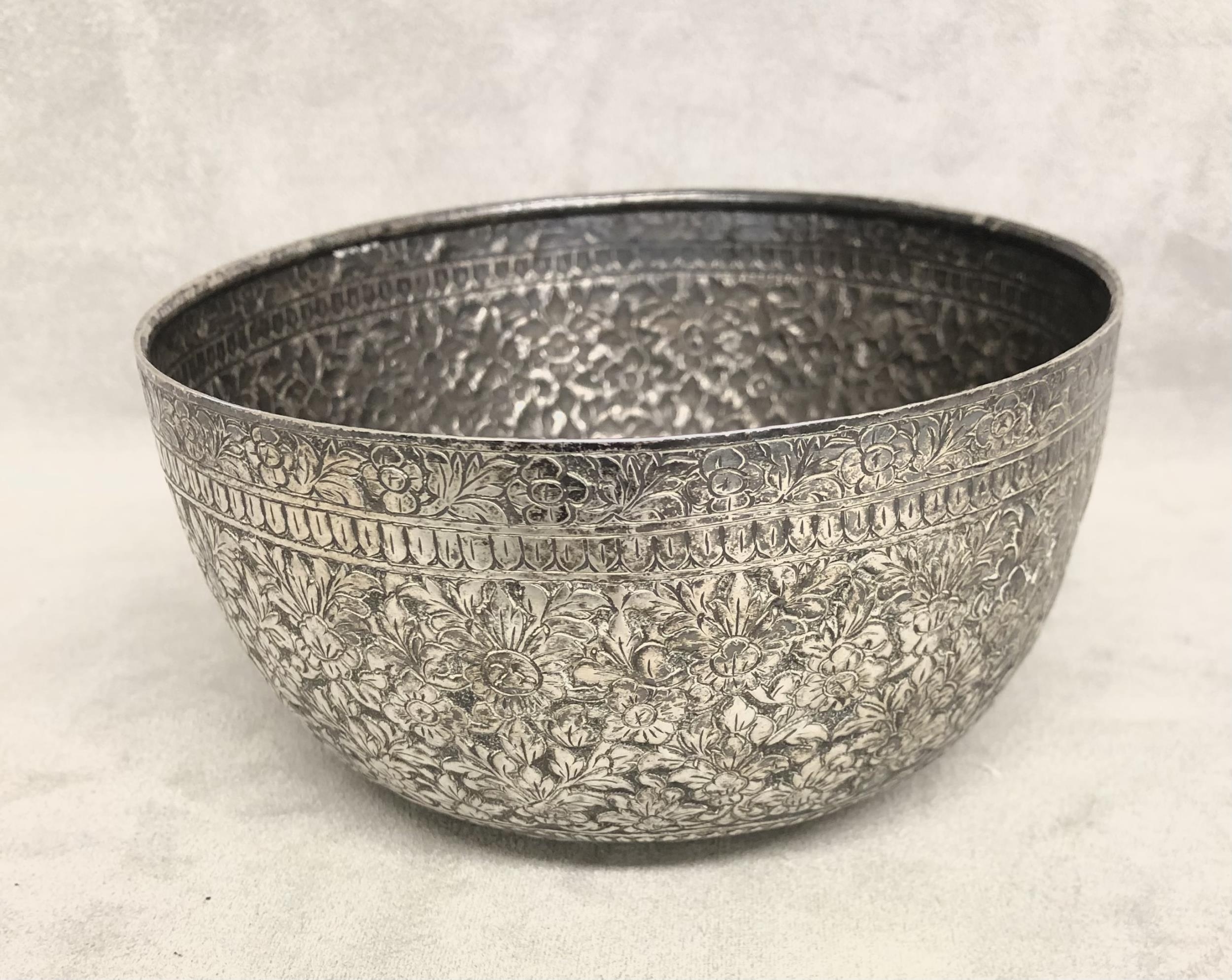 A South Asian white metal bowl with chased floral decoration. 13cm(d) 128g. - Image 4 of 4