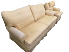 Three seater sofa upholstered in yellow fabric, and a matching arm chair
