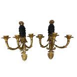 A pair of classical gilded three branch carved wooden wall sconces, with carved faces in the style