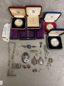 A collection of sterling silver and white metal jewellery items together with commemorative white