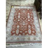 Rug: Persian style, with terracotta ground and beige borders, 237cmLong x 176cmW, stain at one