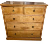 A large honey coloured chest of 2 short over 3 long graduated drawers, some wear to bottom left